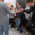 chłopcy w pracowni fizycznej wykonują wraz z pracownikiem naukowym doświadczenia.jpg