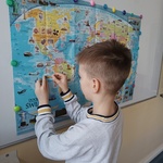 Chłopiec uzupełnia mapę świata naklejkami.jpg