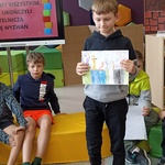 Chłopiec zachęca do przeczytania książki o literkach..jpg