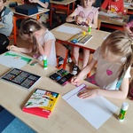 Uczniowie siedzą przy stolikach i wykonuja prace plastyczną.jpg