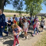 Grupa uczniów z klas drugich idzie za przewodnikiem wzdłuż rzeki w Supraślu.jpeg