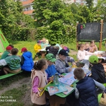 Grupa dzieci podcza zajęc na świezym powietrzu..jpg