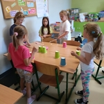 Grupa dziewczynek w klasie wspólnie bawi się w ustawianie kolorowych kubków na ławkach..jpg
