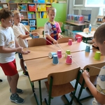 Chłopcy w klasie wspólnie układają kolorowe kubki_ używając narzędzia z gumki recepturki i sznurków..jpg