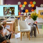 W bibliotece 2 uczennice siedzą na fotelach. Obok siedzi nauczyciel i uczniowie..jpg