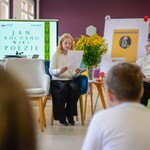 W bibliotece 2 uczennice siedzą na fotelach i czytają. W tle stolik z kwiatami_ telewizor z prezentacją..jpg