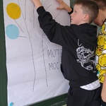 Chłopiec przyczepia do schematu drzewa  kropkę z zapisaną swoją mocną stroną.jpg