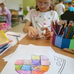 Dziewczynka w okularach pracuje nad matematycznymi puzzlami w kształcie kropki..jpg