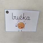 Kartka z napisem buźka i rysunkiem uśmiechniętej kropki tańczącej z nutkami_ przypięta do ściany..jpg