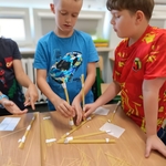 Chłopcy współpracują przy budowie konstrukcji z makaronu spaghetti i taśmy papierowej.jpg