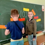Dwóch chłopców przy tablicy z kolorowymi kartkami przypiętymi magnesami..jpg