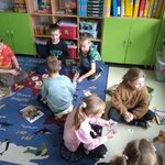 grupki uczniów z kl.2c siedzą na podłodze grają w gry.jpg