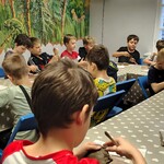 Klasa podczas warsztatów W pracowni rzeźbiarza. Dzieci siedzą przy stole i lepią z gliny..jpg