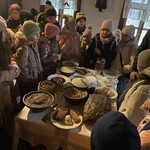 Dzieci zgromadzone wokół stołu wigilijnego patrzą_ jakie potrawy się na nim znajdują.jpeg