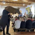 Uczniowie podczas oglądania przedstawienia teatralnego obserwują Turonia podchodzącego do nich.jpeg