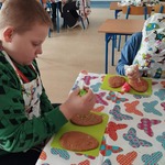 Dwoje chłopców przy stoliku dekoruje ciastka wielkanocne.jpg
