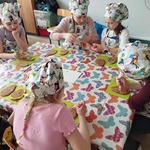 Grupa dziewczynek przy stoliku ozdabia ciastka masą cukrową.jpg