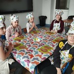 Grupa uczennic przy stoliku pozuje do zdjęcia przed ozdabnianiem ciastek wielkanocnych.jpg