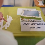 Na stoliku leży pudełko_ karteczki i napis Czytelniczy konkurs z fantami..jpg