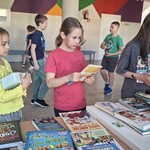 Trzy uczennice stoją przy stole z książkami..jpg
