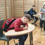 W sali dwóch uczniów siedzi przy stolikach_ uzupełniają karty do głosowania..jpg