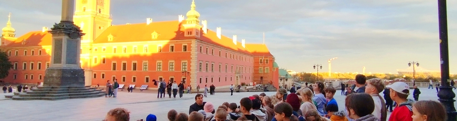 Grupa dzieci słucha przewodnika przy Kolumnie Zygmunta III Wazy w Warszawie.jpg