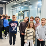Grupka uczniów pozuje do zdjęcia przy wystawie edukacyjnej w Fabryce Czekolady Wedel.png