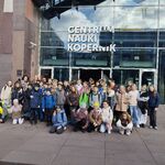 Uczniowie klas czwartych wraz z opiekunami pozują do pamiątkowego zdjęcia przed Centrum Nauki Kopernik w Warszawie.jpg