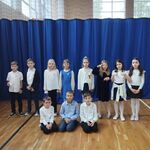 Uczniowie z klasy 2 c ubrani w galowe stroje pozują do zdjęcia po odśpiewaniu hymnu Polski.jpg