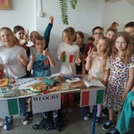 grupa dzieci przy stoisku prezentuje Włochy.jpg